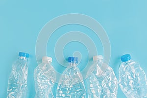 Crashed plastic bottles on blue background. Recycling plastic utilisation concept. Ecological problem, environmental pollution,