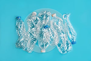 Crashed plastic bottles on blue background. Recycling plastic utilisation concept. Ecological problem, environmental pollution,