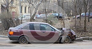 A crashed red car after an accident on the road