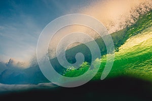 Crashing big wave in ocean. Breaking green wave and sun light in Bali