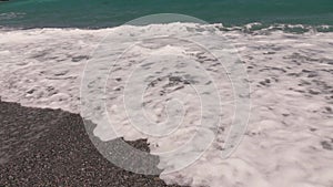 Crashing sea waves on empty pebble beach, slow motion