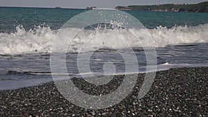 Crashing sea waves on empty pebble beach, slow motion