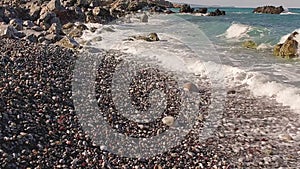 Crashing sea waves on empty pebble beach, slow motion