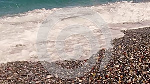 Crashing sea waves on empty pebble beach, slow motion