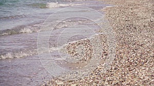 Crashing sea waves on empty pebble beach, slow motion