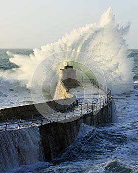 Crashing wave over harbour wall