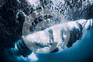 Crashing wave with foam and air bubbles underwater. Transparent sea water