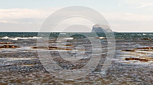 Crashing waves on the coast with Bass Rock in the background