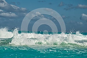 Crashing waves a few clouds and blue sky