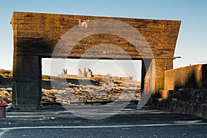 Craster Harbour framing Dunstanburgh Castle photo