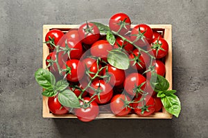Crate with fresh cherry tomatoes on stone background