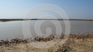 Crater with gray volcanic healing clay. A hole with a prominent amorphous mass from the depths of the earth. Mud and gas