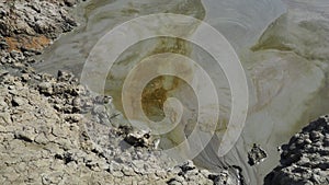 Crater with gray volcanic healing clay. A hole with a prominent amorphous mass from the depths of the earth. Mud and gas