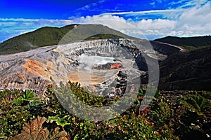 The crater and the lake of the Poas volcano in Costa Rica. Volcano landscape from Costa Rica. Active volcano with blue sky with cl photo