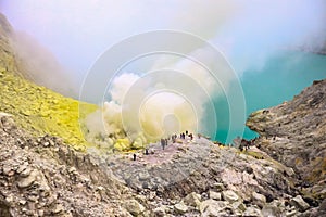 Crater of a volcano with a green sulfuric volcanic lake and volcanic smoke. View of the smoking volcano Kawah Ijen in Indonesia. M