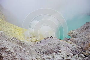 Crater of a volcano with a green sulfuric volcanic lake and volcanic smoke. View of the smoking volcano Kawah Ijen in Indonesia. M