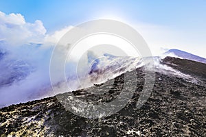 Cratere cima Etna - vista panoramica durante giornata di sole con emissione di vapore e gas photo