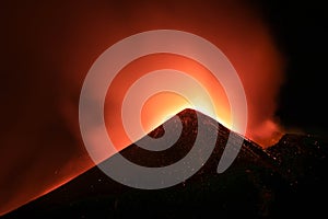 Cratere Etna in eruzione in primo piano durante suggestiva notte con lava incandescente ed emissione di cenere e fumo