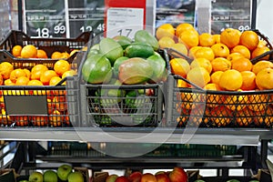Crates with ripe orange and grapefruits on shelves