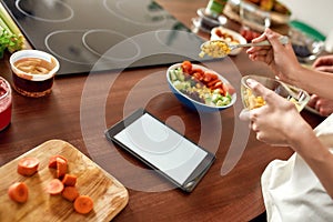 Crave The Taste. Close up of process of cooking. Woman preparing healthy meal in the kitchen checking recipe using