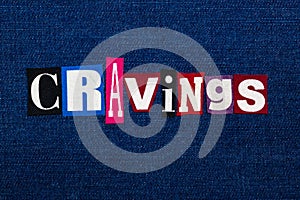 CRAVINGS word text collage, multi colored fabric on blue denim, uncontrollable urge concept