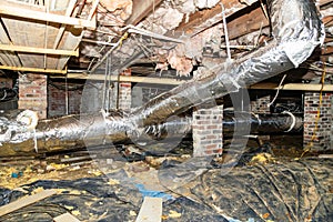 Crawl Space under house with air conditioner duct work and insulation photo