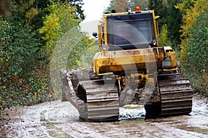 Crawler bulldozer rides on a dirt road