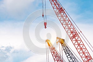 Crawler crane against blue sky and white clouds. Real estate industry. Red crawler crane use reel lift up equipment in