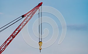 Crawler crane against blue sky and white clouds. Real estate industry. Red crawler crane use reel lift up equipment in