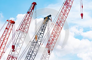 Crawler crane against blue sky and white clouds. Real estate industry. Red crawler crane use reel lift up equipment in