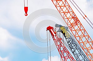 Crawler crane against blue sky and white clouds. Real estate industry. Red crawler crane use reel lift up equipment in