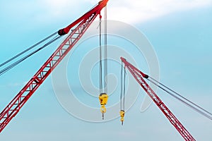 Crawler crane against blue sky and white clouds. Real estate industry. Red crawler crane use reel lift up equipment in