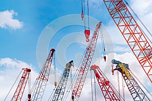 Crawler crane against blue sky and white clouds. Real estate industry. Red crawler crane use reel lift up equipment in