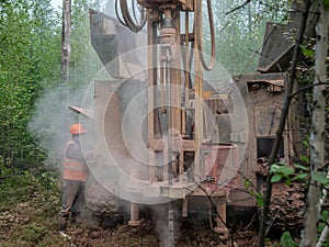 Crawler drilling rig drills well, lot of dust when drilling borehole