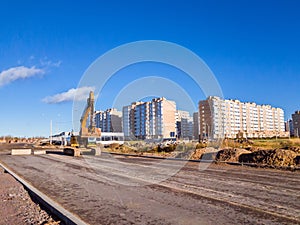 Crawler excavator with bucket, construction road