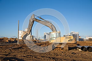 Crawler excavator at a construction site during digging ground for laying sewer pipes. Backhoe on earthworks at construction site