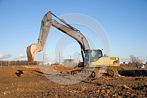 Crawler excavator at a construction site during digging ground for laying sewer pipes. Backhoe on earthworks at construction site