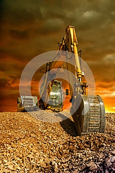 Crawler excavator during earthmoving works on construction site at sunset