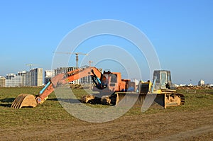 Crawler excavator with iron bucket and bulldozer at construction site.