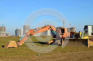 Crawler excavator with iron bucket and bulldozer at construction site. Land clearing, grading, pool excavation, utility trenching