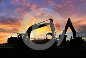 Crawler excavators silhouette are digging the soil in the construction site.