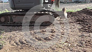 Crawler tracks of moving excavator in operation on a dirt site