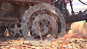 Crawler tracks of a plowing tractor and a field in early spring, a plowed field for crops, close-up,