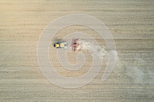 Crawler tractor harrowing and leveling soil for next seeding in rural plain fields