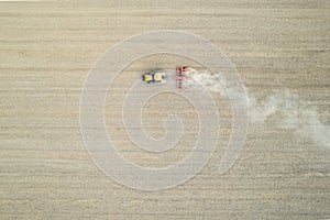 Crawler tractor harrowing and leveling soil for next seeding in rural plain fields