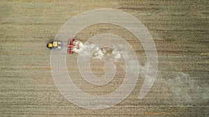 Crawler tractor harrowing and leveling soil for next seeding in rural plain fields