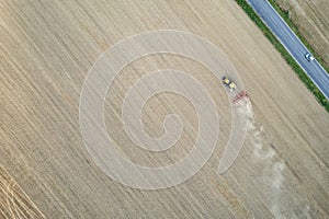 Crawler tractor harrowing and leveling soil for next seeding in rural plain fields