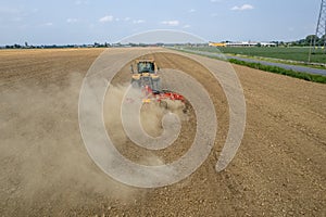 Crawler tractor harrowing and leveling soil for next seeding in rural plain fields