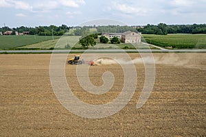 Crawler tractor harrowing and leveling soil for next seeding in rural plain fields