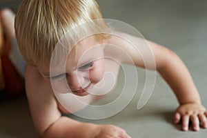 Crawling around the house. A cute little baby boy crawling along the floor.